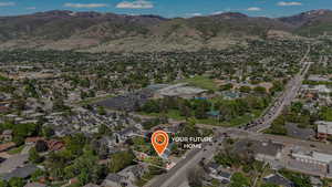 Aerial overview of property's location featuring a mountainous background and nearby suburban area