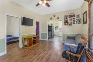 Sitting room featuring ceiling fan, wood finished floors, and baseboards