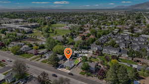 Aerial view of property and surrounding area featuring mountains, property parcel outlined, and nearby suburban area