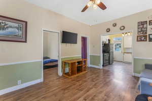 Living area featuring hardwood / wood-style flooring, ceiling fan, and baseboards