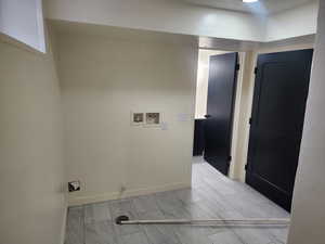 Clothes washing area featuring washer hookup and baseboards