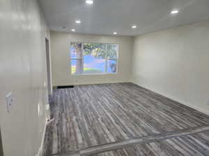 Spare room featuring wood finished floors, recessed lighting, and baseboards