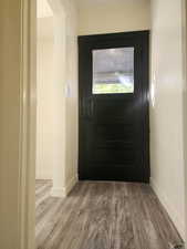 Entryway with baseboards and wood finished floors