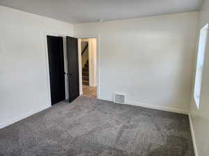 Empty room featuring carpet floors and baseboards
