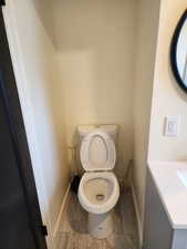Bathroom with baseboards, toilet, and vanity