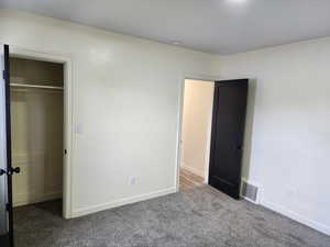 Unfurnished bedroom with carpet floors, baseboards, and a closet