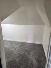 Additional living space featuring carpet floors, vaulted ceiling, and baseboards