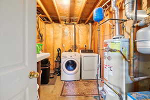 Laundry room with separate washer and dryer and gas water heater