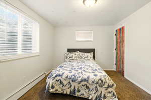 Bedroom featuring a baseboard radiator, carpet flooring, and baseboards