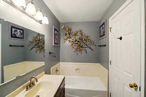Full bath with vanity and a bath