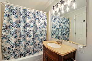 Bathroom featuring ornamental molding, vanity, and shower / tub combo