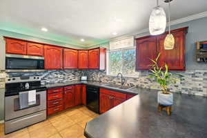 Kitchen featuring appliances with stainless steel finishes, a sink, dark brown cabinets, ornamental molding, and dark countertops