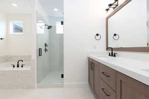 Bathroom featuring a shower stall, healthy amount of natural light, a garden tub, baseboards, and recessed lighting