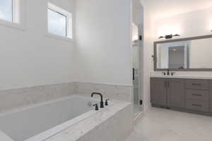 Bathroom featuring vanity, a stall shower, and a garden tub