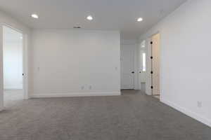 Carpeted spare room with recessed lighting and baseboards