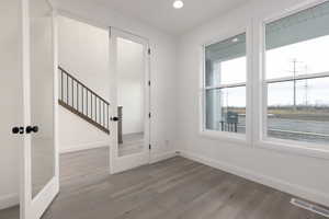 Entrance foyer with wood finished floors, baseboards, recessed lighting, and french doors