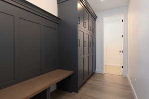 Mudroom with light wood-style floors and baseboards
