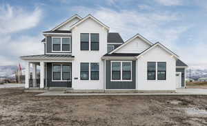 View of front of property with a porch, a standing seam roof, board and batten siding, and roof with shingles