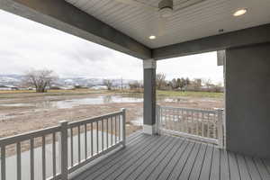 Wooden terrace featuring covered porch and a water view
