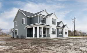View of front of house with covered porch, central air condition unit, and a shingled roof