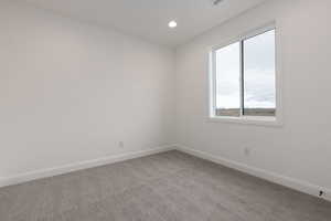 Empty room with baseboards, light carpet, and recessed lighting