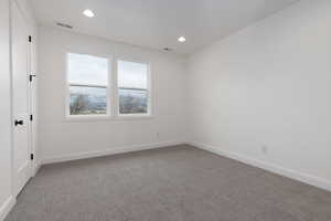 Carpeted spare room featuring baseboards and recessed lighting