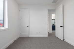 Unfurnished bedroom with carpet floors and baseboards