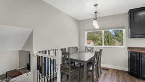 Dining space with dark wood-type flooring, baseboards, and a textured ceiling