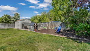 View of yard featuring a playground and an outbuilding