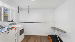 Clothes washing area featuring separate washer and dryer, dark wood-type flooring, and an ornate ceiling