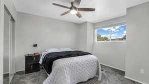 Carpeted bedroom with baseboards, a textured ceiling, a ceiling fan, and a closet
