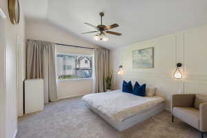 Bedroom with lofted ceiling, carpet flooring, ceiling fan, and baseboards