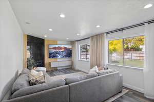 Living area featuring recessed lighting, wood finished floors, baseboards, and a textured ceiling