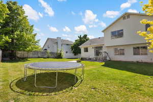 Rear view of property featuring a trampoline