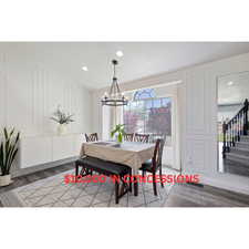 Dining area featuring a chandelier, a decorative wall, wood finished floors, stairway, and recessed lighting