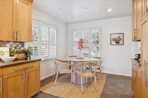 Dining room with healthy amount of natural light, baseboards, and dark tile patterned floors