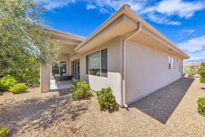 View of side of property featuring a patio and stucco siding