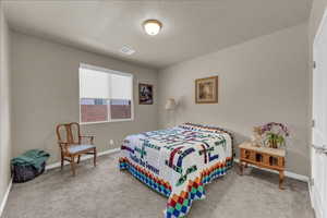 Carpeted bedroom featuring baseboards and a textured ceiling