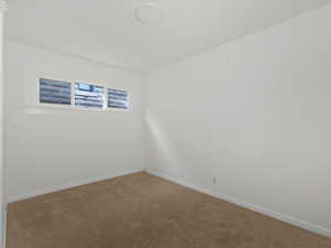 Carpeted spare room with baseboards