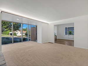 Carpeted spare room featuring baseboards