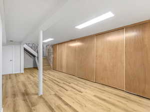Bonus room with light wood finished floors and stairway