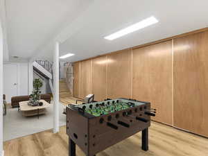 Game room with light wood-style flooring