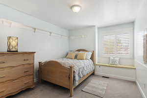 Bedroom with light colored carpet and baseboards
