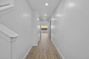 Hall with light wood-style flooring, recessed lighting, and baseboards