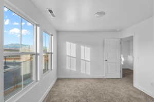 Carpeted spare room featuring baseboards