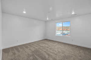 Carpeted spare room featuring recessed lighting and baseboards