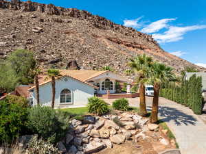 View of front of home with driveway, a mountain view, stucco siding, and a tiled roof