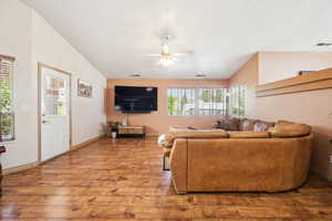 Living area featuring wood-type flooring, ceiling fan, and baseboards