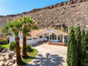 Mediterranean / spanish-style house featuring driveway, a garage, a tile roof, and stucco siding