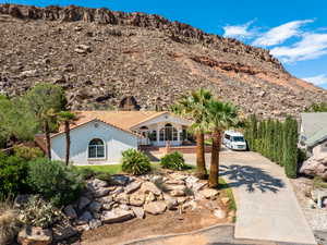 View of front of home with driveway, stucco siding, and a mountain view
